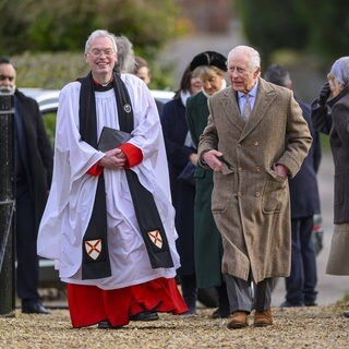 König Charles geht mit dem Pfarrer der Kirche von Flitcham zum Gottesdienst. 