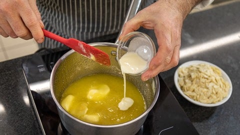 Butter, Zucker und Honig werden aufgekocht, dann kommt ein Schuss Sahne dazu und zum Schluss jede Menge Mandelblättchen. Fertig ist der Crunch!