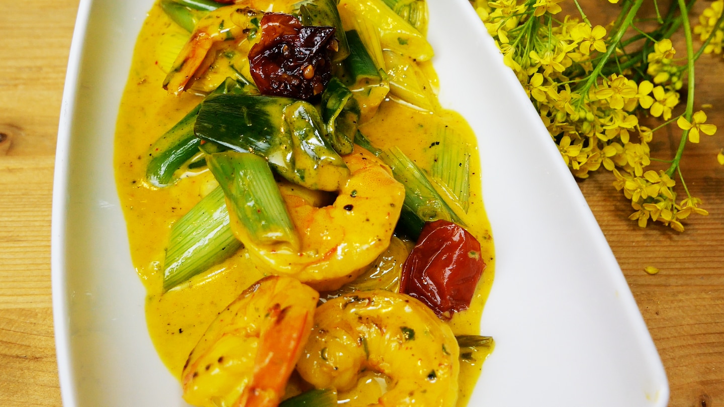 Exotischer Salat aus Garnelen und Frühlingszwiebeln mit gelber Currysoße