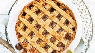 Linzer Torte (Kuchen mit Gitter aus Teig obenauf) mit Kastanien als Deko daneben