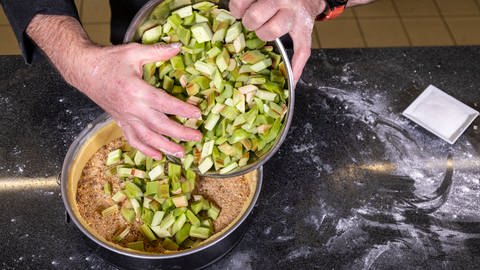 Der geputze, geschälte und klein geschnittene Rhabarber kommt in den Boden aus Mürbteig - das ist das Herz für den Rhabarberkuchen.