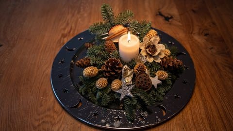 Eine Schale mit Weihnachtsdekoration steht auf einem Tisch.