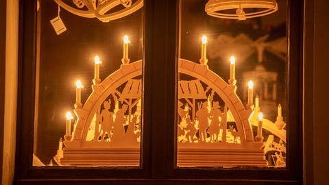Weihnachtsdeko im Fenster: Ein Schwibboggen mit LED-Kerzen.