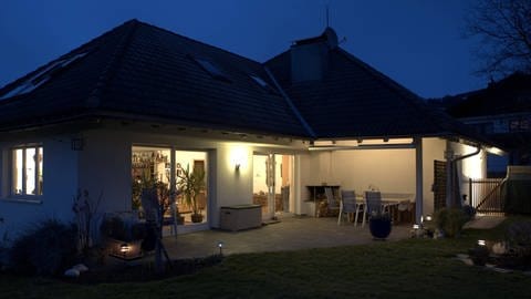 Gartenbeleuchtung: Haus außen beleuchtet mit Solarlampen im Garten und Wandbeleuchtung