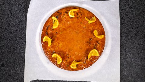 Die fertig gebackene Queen Mary's Tarte wird mit Aprikosenmarmelade bestrichen und Orangenstücken garniert. Fertig ist der schottische Kuchen für eine royale Tea Time!