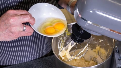 Die Eier werden zu dem Teil in der Rührmaschine hinzugefügt: Die Zutaten für die Queen Mary's Tarte werden schaumig geschlagen, um einen lockeren und fruchtigen Kuchengenuss aus Schottland zu zaubern.