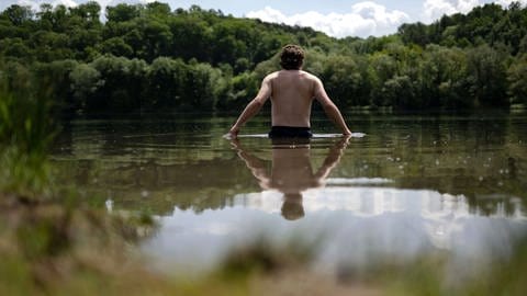 Ein junger Mann geht in den Kirchentellinsfurter Baggersee, der auch Epplesee genannt wird.