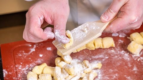 Gnocchi selber machen: Die "Klößchen" werden über ein Butterbrettchen gerollt.