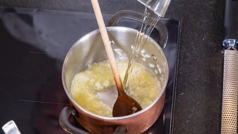 Gnocchi mit Parmesanschaum: Die Schalotten werden in einem Topf glasig angedünstet.