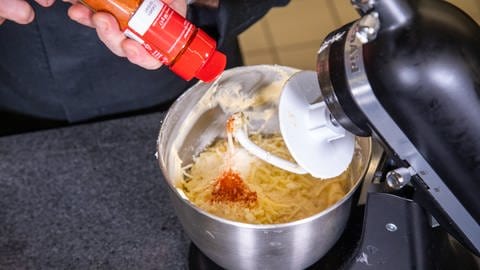 In den Teig für den Kuchen in einer Rührschüssel kommt Paprikapulver: Für den Gugelhupf in herzhaft mit Gemüse braucht es einene "All-in-Teig".