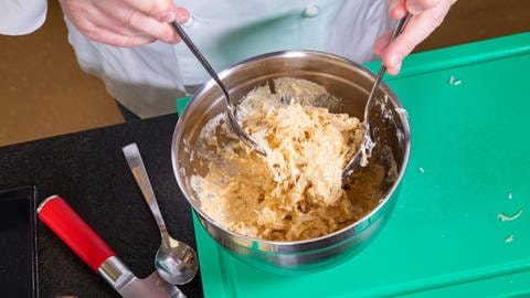 Das ausgepresste Sauerkraut wird hier unter das Joghurtdressing gemischt.