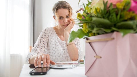 Handysucht: Wenn der Blick aufs Handy zur Gewohnheit wird, wie bei der Frau, die auf den schwarzen Bildschirm schaut.