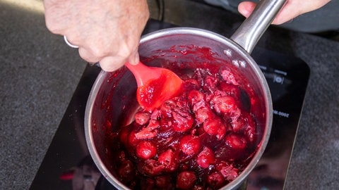 Rezept für Schwarzwälder Kirsch als Rolle: Die Kirschen werden mit Zucker und Kirschsaft augekocht.