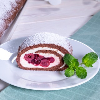 Rezept für Schwarzwälder Kirsch-Rolle als Variante der Schwarzwälder Kirschtorte: Ein Stück der Rolle auf einem Teller.