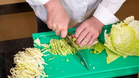 SWR4 Koch Jörg Ilzhöfer schneidet für sein Rezept auf einem Brett den Wirsing in Streifen von einem halben Zentimeter: So mischt sich das Gemüse einfach mit den Bandnudeln.