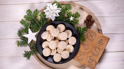 Springerle auf einem Teller, drum herum adventliche Dekoration: Die traditionellen Plätzchen sind an Weihnachten besondere Hingucker.