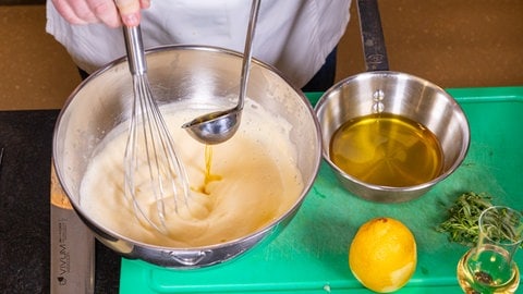 Nach Rezept Butter zu Hollandaise geben.