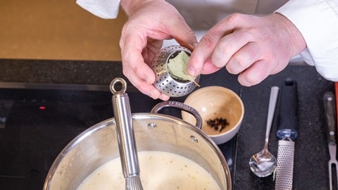 Kräuter werden in ein Teesieb gegeben und in der Suppe mitgekocht.