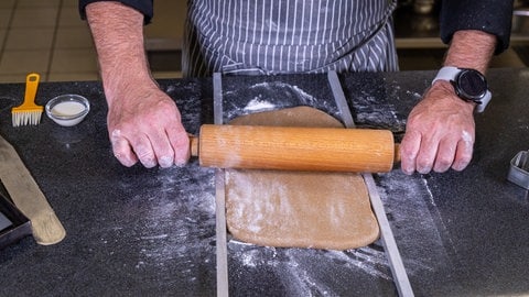 Nikolausstiefel backen: Der Teig wird mit einem Nudelholz ausgerollt.