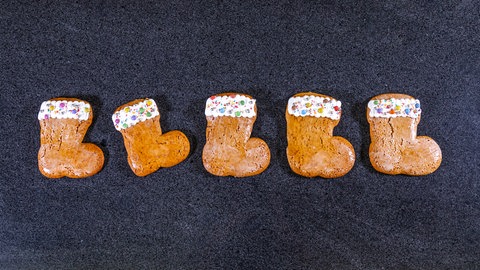 Nikolausstiefel backen: Fünf fertige Stiefelchen aufgereiht auf einem Tisch