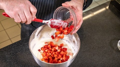 Erdbeer-Sahne-Schnitten backen: Die Erdbeeren werden in die Sahne-Creme untergehoben.