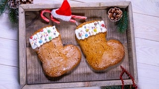 Nikolausstiefel backen: Die fertigen Nikolausstiefel sind schön angerichtet auf einem Holzbrett mit Tannenzweigen.