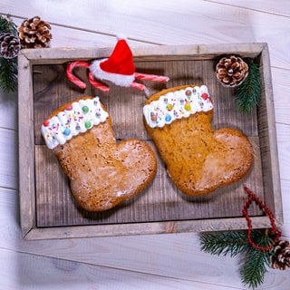 Nikolausstiefel backen: Die fertigen Nikolausstiefel sind schön angerichtet auf einem Holzbrett mit Tannenzweigen.