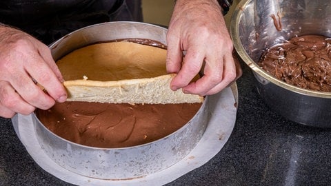 Tortenboden und Schokoladencreme in einem Backring schichten.