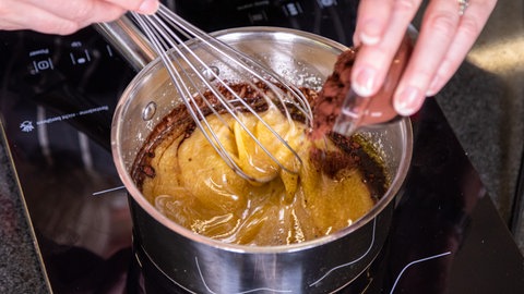 Rezept Schokokuchen: Butter in einem Topf auf dem Herd schmelzen und den Kakao dazu mischen.