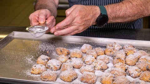 Stollenkonfekt wird mit Puderzucker bestreut