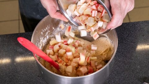 Die frischen Rhabarber-Stücke für die Rhabarberschnitte werden, wie im Rezept beschrieben, dem Teig einfach hinzugefügt.