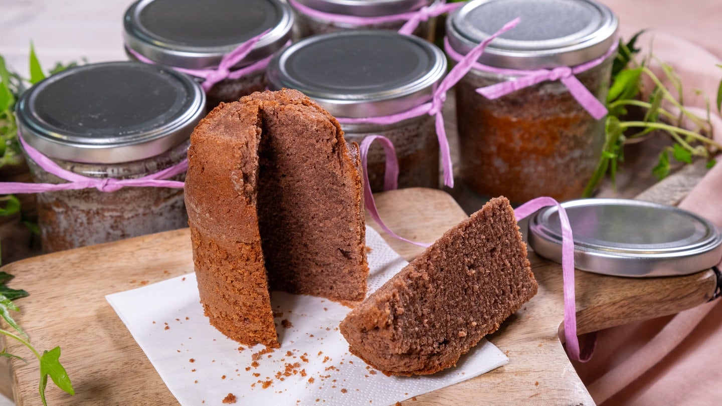 Der fertige Kuchen im Glas liegt auf einem Schneidebrett. Der Kuchen ist, wie im Rezept beschrieben, ein halbes Jahr haltbar.