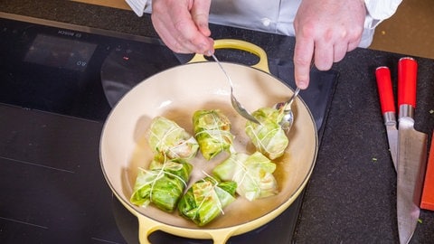 Rezept Kohlrouladen mit Hackfleisch: Die Kohlrouladen werdcen mit etwas Butterschmalz in einer Pfanne angebraten.