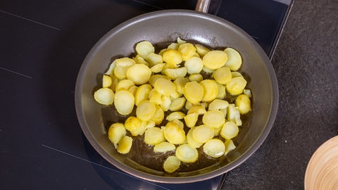 Kartoffelscheiben in der Pfanne, angebraten in Butterschmalz: Für Hoppelpoppel, das Bauernfrühstück aus Berlin, ist die gehaltvolle Grundlage alles.