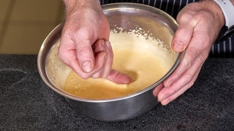 Rezept Orangenparfait, Dessert für Weihnachten: Mit einem kleinen Finger wird die Konsistenz einer Eigelb-Zucker-Masse überprüft.