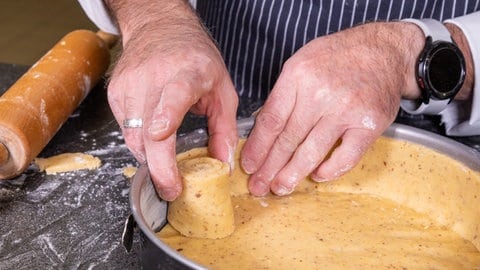 Rezept für Apfelkuchen mit Gitter: Ein Streifen aus Teig wird in der Backform so ausgerollt, dass er am Rand der Kuchenform steht und haftet.