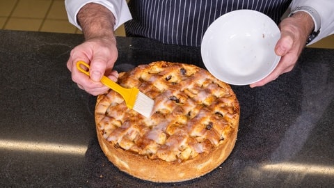 Rezept für Apfelkuchen mit Gitter: Das Gitter auf dem saftig gebackenen Kuchen wird einfach mit einer leckeren Zuckerglasur bestrichen.