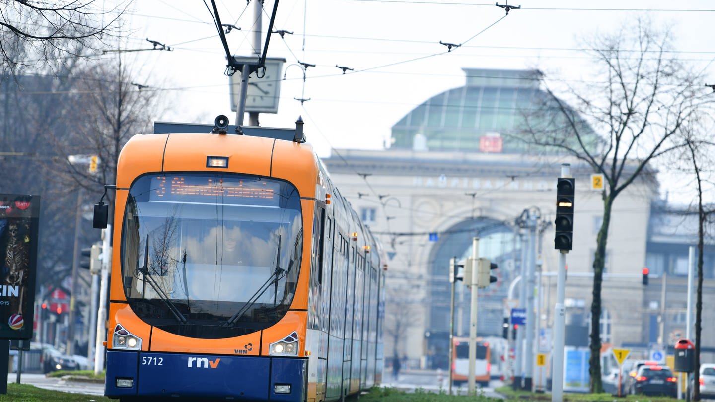 16.02.2018, Baden-Württemberg, Mannheim: Eine Straßenbahn fährt vor dem Eingang zum Hauptbahnhof über die Gleise.