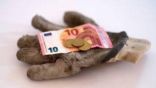 Bargeld liegt auf einen Arbeitshandschuh