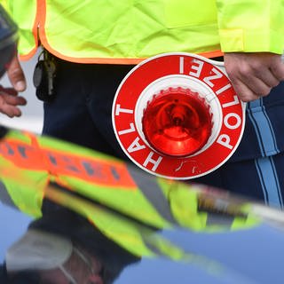 Ein Verkehrspolizist kontrolliert einen Verkehrssünder am Straßenrand