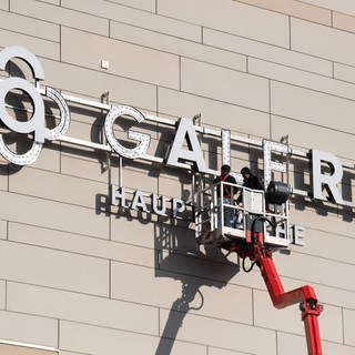 Arbeiter montieren ein "Galeria"-Logo - bald könnte es wieder abgenommen werden.