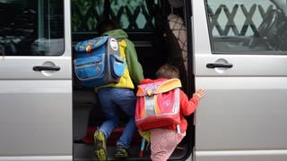 Eltern fahren Kinder zur Schule