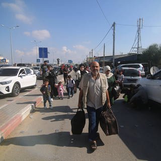 Menschen kommen am Grenzübergang Rafah an.