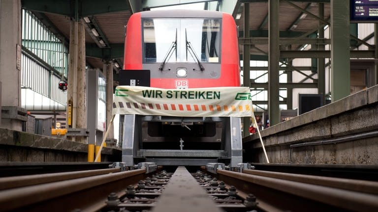 Ein Banner mit der Aufschrift "Wir streiken" steht am 01.09.2014 auf dem Hauptbahnhof in Stuttgart (Baden-Württemberg) vor einem Regionalzug. Die Gewerkschaft Deutscher Lokomotivführer (GDL) hat im Tarifstreit mit der Deutschen Bahn erneut zum Streik aufgerufen.