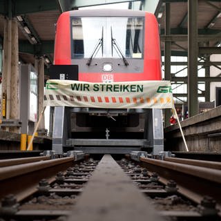 Ein Banner mit der Aufschrift "Wir streiken" steht am 01.09.2014 auf dem Hauptbahnhof in Stuttgart (Baden-Württemberg) vor einem Regionalzug. Die Gewerkschaft Deutscher Lokomotivführer (GDL) hat im Tarifstreit mit der Deutschen Bahn erneut zum Streik aufgerufen.