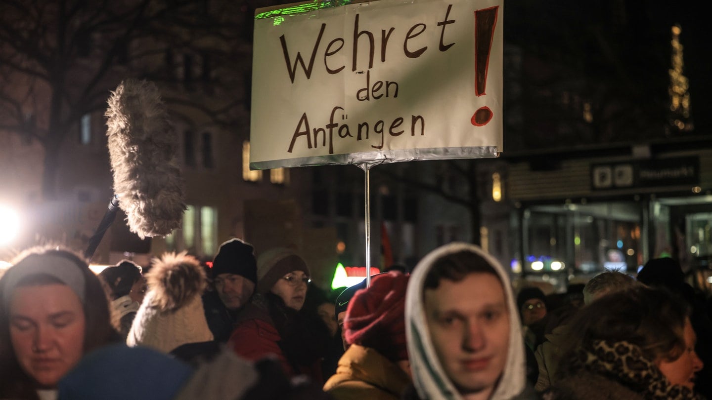 Demonstranten tragen ein Schild mit der Aufschrift „Wehret den Anfängen“. Zahlreiche Menschen bei einer Demonstration des 