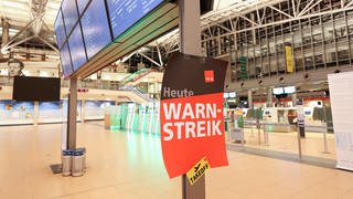 Ein Plakat mit der Aufschrift "Warnstreik!" hängt im Terminal 2 am Flughafen Hamburg
