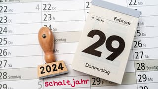 Kalender mit dem Datum 29. Februar neben Stempel mit Aufschrift 2024 und Kalender mit Aufschrift Schaltjahr 