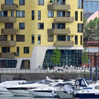 Die goldene Fassade eines Neubaus für Eigentumswohnungen leuchtet im Mainzer Zollhafen.