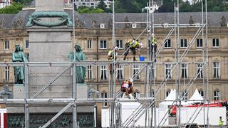 Bauarbeiter arbeiten auf einem Gerüst auf dem Schlossplatz in Stuttgart